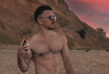 Genç bir adam ve bir şişe parfüm.