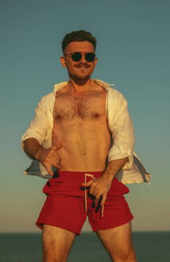 Genç adam denize karşı eğleniyor.