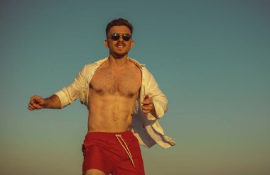 Genç adam gökyüzüne karşı eğleniyor.