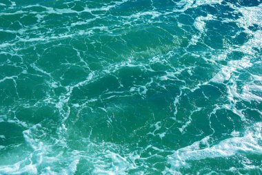 Mavi, kaynayan, köpüklü deniz suyu.