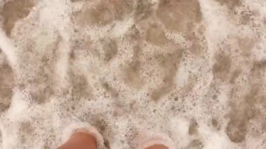 Okyanus kadın ayaklarını yıkar. Tatil sembolü.