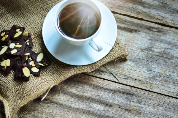 Ahşap arka planda bir fincan kahve ve lezzetli kurabiyeler. Çay saati ve kahvaltı konsepti.