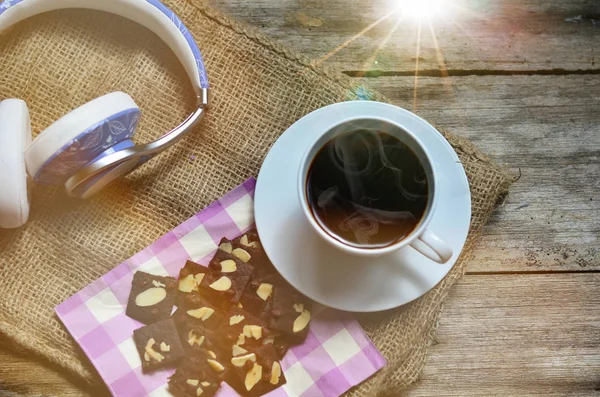 Ahşap arka planda bir fincan kahve ve lezzetli kurabiyeler. Çay saati ve kahvaltı konsepti.