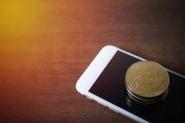 Fiziksel Bitcoins yığını ile smartphone sanal para kavramı