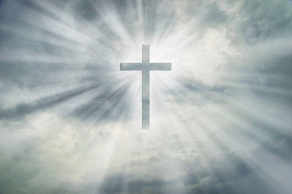 Christian cross appears bright on dramatic dark sky background