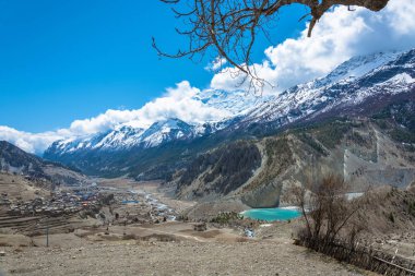 Manang, Nepal Köyü yakınlarında küçük bir zümrüt göl. Güzel karlı dağ zirveleri ve Himalayalar bulutlarda. 