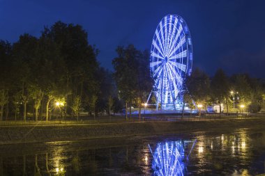 Ivanovo nehir Uvod dolgu üzerinde karanlık gökyüzü karşı bir parlak ışık saçan gözlem tekerleği. 