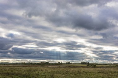 Güneşin parlak ışınları bulutlu bulutların arasından sonbahar akşam, Rusya pierce..