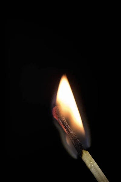 Světlé hořící zápalkou na černém pozadí, záběr zblízka. — Stock fotografie