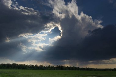 Bir gree üzerinde bir gök gürültüsü bulutu ve güneş ışığı ile güzel manzara