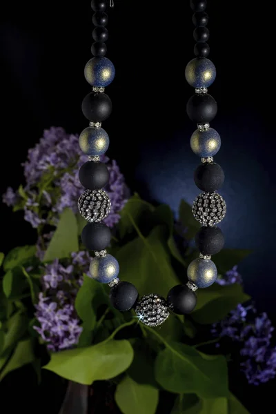Eine Perlenkette aus runden kleinen schwarzen und leicht glänzenden Kugeln. — Stockfoto