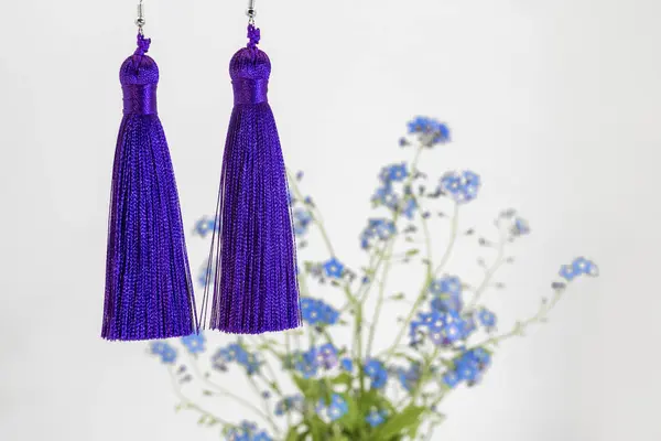 Zwei leuchtend lila Ohrringe-Pinsel und ein blauer Strauß Vergissmeinnicht — Stockfoto