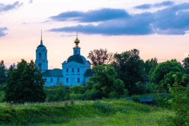 Akşam gökyüzüne karşı bir çan kulesi ile taş beyaz kilise. 