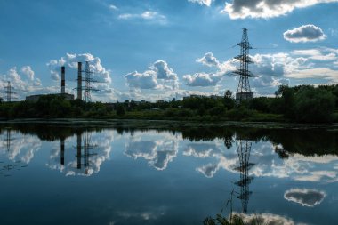 Elektrik hattının yansıması ve kara kümülüs bulutları bir yaz günü suyun içinde..