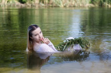Yazın ormanda nehirde uzun sarı saçlı genç beyaz bir kadın.