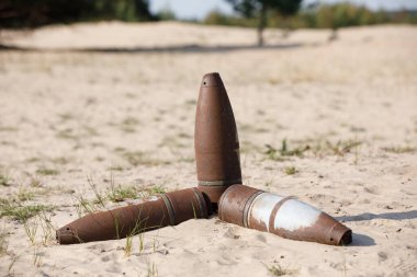 Yerde paslı topçu mermileri var.