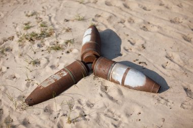 Yerde paslı topçu mermileri var.
