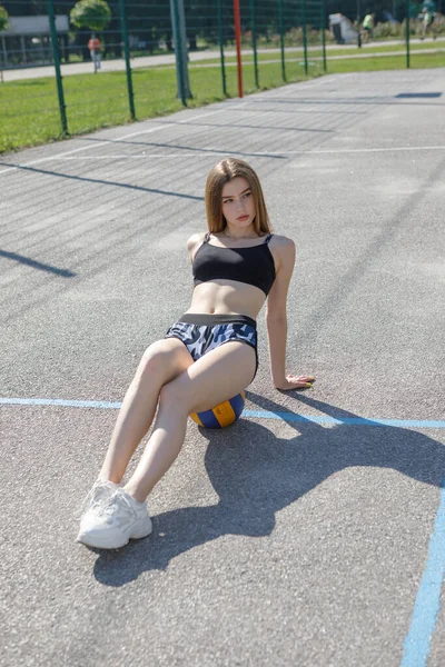 Junge Sportlerin Mit Langen Haaren Sitzt Mit Ball Auf Dem — Stockfoto