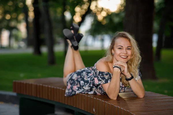Piękna Młoda Kobieta Blond Kręconymi Włosami Sukience Okularach Leżących Parku — Zdjęcie stockowe