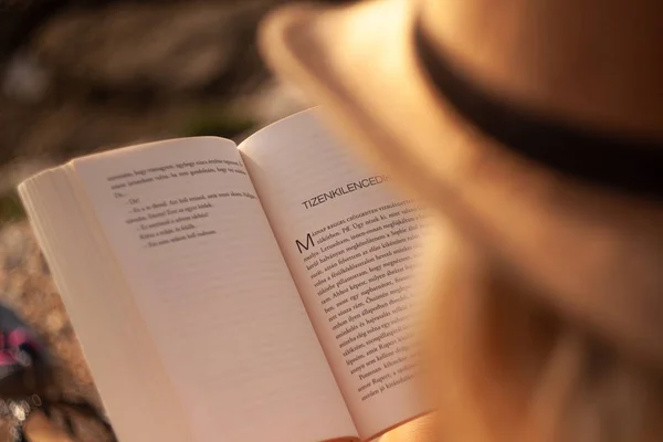 Junge blonde Frauen mit Strohhut lesen ein Buch — Stockfoto