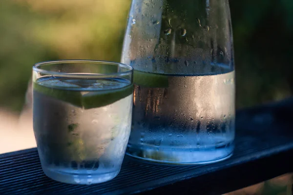 Bottiglia e bicchiere di acqua fredda con gocce d'acqua — Foto Stock
