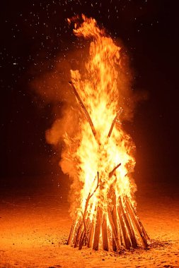 Kumsalda yangın var. Ateşin kıvılcımları gece gökyüzüne uçar.
