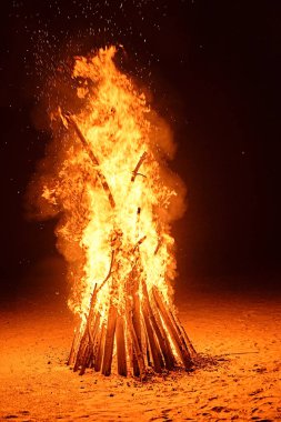 Kumsalda yangın var. Ateşin kıvılcımları gece gökyüzüne uçar.
