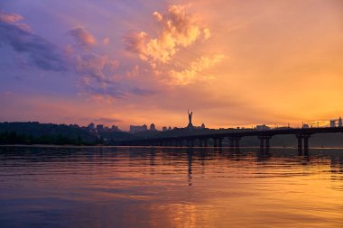 Kyiv 'deki Dinyeper nehrinde turuncu mavi gün batımı. Köprünün panoraması. Gökyüzündeki bulutlar.