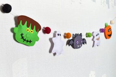 Cadılar Bayramı 'nda çelenk gibi hissettim. Yün topları ve semboller. Frankenstein, balkabağı, hayalet, vampir ve vudu bebeği. El yapımı kumaş.