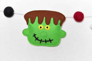 Cadılar Bayramı 'nda çelenk gibi hissettim. Yün topları ve semboller. Frankenstein, balkabağı, hayalet, vampir ve vudu bebeği. El yapımı kumaş.