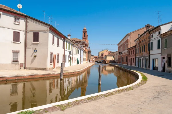 Comacchio , İtalya, dar sokakları, kanallar ve küçük bir Venedik gibi köprüler ile güzel bir şehir. Temiz mavi gökyüzünün altında suya yansıyan evler.