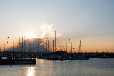 İtalya 'nın Gabicce kentindeki Adriyatik Denizi' nde romantik bir gün batımı. Renkli bulutlu bir gökyüzünün altında limanda tekneler ve yatlar.