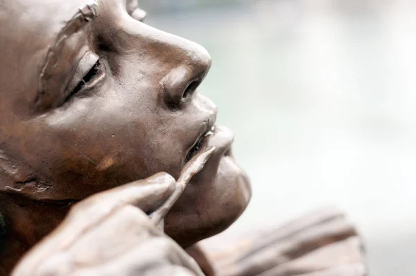detail of a statue of a clown looking at a magic mirror in Bratislava, Slovakia.