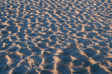 Sahilde gün doğumu. Kum dokusu.