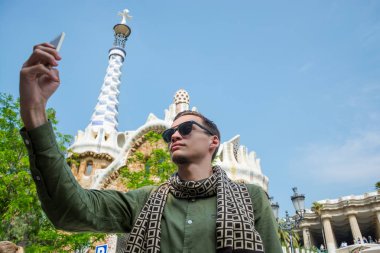 Genç bir adam bir selfie yapar Guell Park bir zencefilli ev, mimar Gaudi Barcelona, İspanya