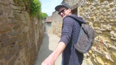 Takip et beni. Genç bir adam bir şapkalı bir kız Carcassonne Fransa eski sokaklar boyunca elle yol açar