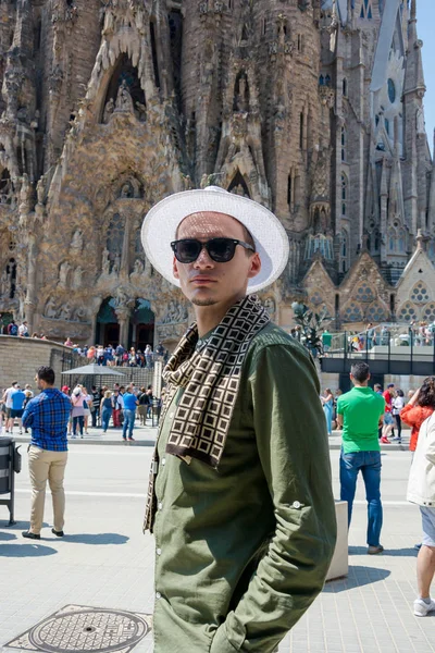 Yazı işleri. Mayıs 2018. Yaz aylarında cephe Sagrada Familia. Genç bir adam, bir turist güneş gözlüğü ve şapka Sagrada Familia için Barselona, İspanya'nın önünde