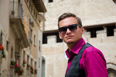 Genç bir adam, bir turist Girona, İspanya bir sokakta duruyor.