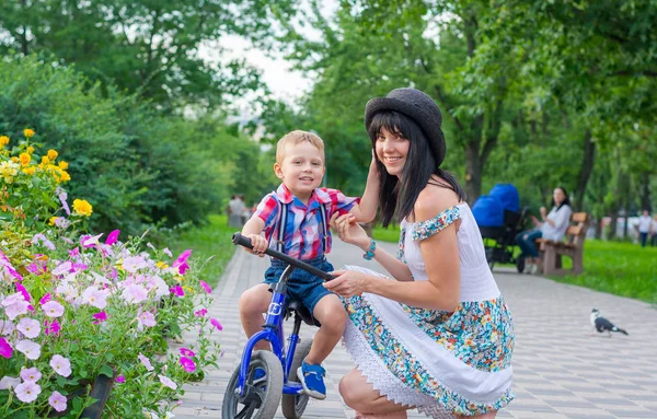 Мама Помогает Маленькому Мальчику Ездить Велосипеде Улыбаться Летнем Парке — стоковое фото