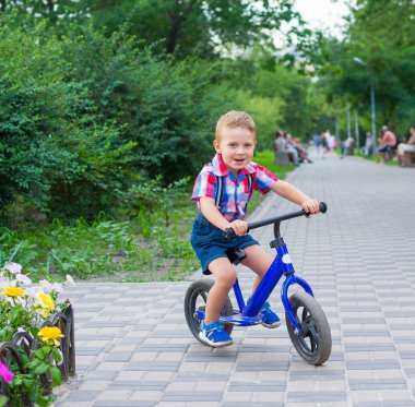 Küçük çocuk parkta Bisiklete binmek yaz aylarında sürme
