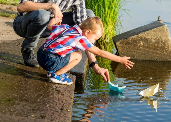 Tata Pomaga Mały Chłopiec Aby Obniżyć Łódź Papieru Wody Parku — Zdjęcie stockowe