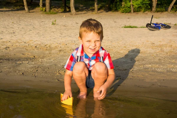 Een Kleine Jongen Lanceert Papieren Boten Het Water Zomer — Stockfoto