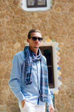 Genç bir adam güneş gözlüklü Guell Park, içinde mimar Gaudi Barcelona, İspanya bir gingerbread house civarındaki standları