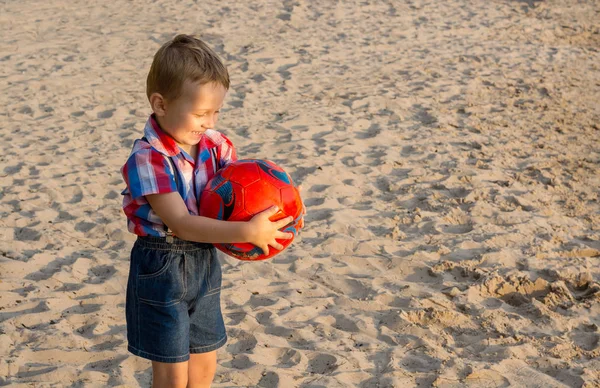 Маленький Мальчик Пляже Мячом Смотрит Мяч Улыбается — стоковое фото