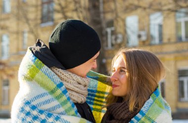 Sevgi dolu çift birbirine bakarak ve ekose kışın gülüyor. Adam bir kız sokakta kışın sarılmak. St. Valentine's Day