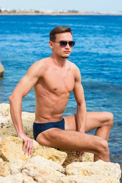 Mladý Pohledný Sportovní Chlap Sedí Pláži — Stock fotografie