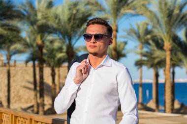 Bir beyaz gömlek ve su genç yakışıklı bir gülümseyen adam portresi