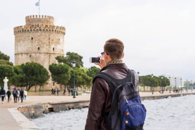 Güneş gözlüklü genç yakışıklı adam, turist, sırt çantalı. 