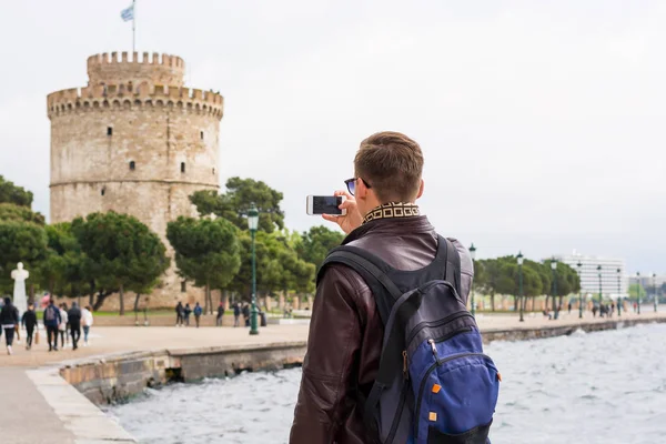 Joven hombre guapo en gafas de sol, turista, con la mochila tomando — Foto de Stock