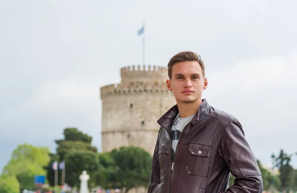 Schöner Mann, Tourist, steht in der Nähe eines weißen Turms im Zentrum — Stockfoto